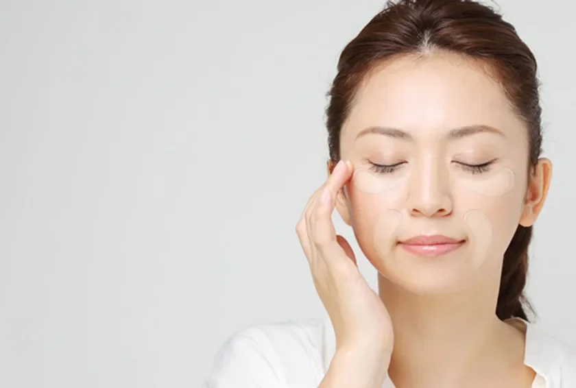 目元と頬にパッチを貼ってケアする女性