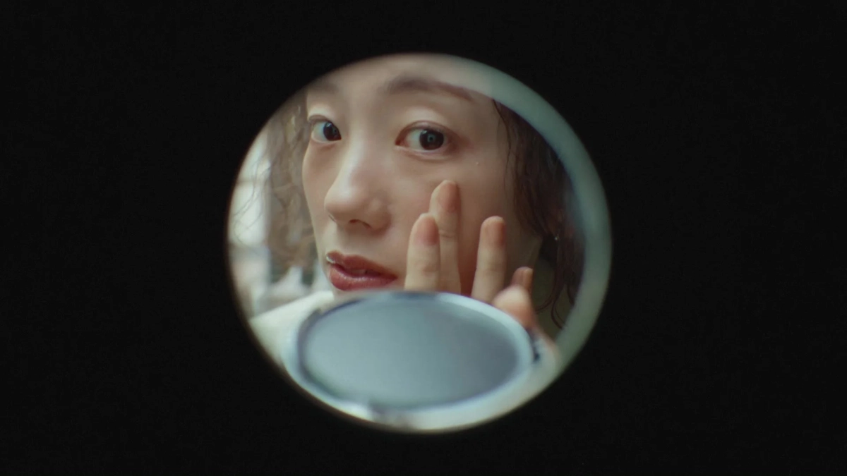 女性の顔を鏡で確認