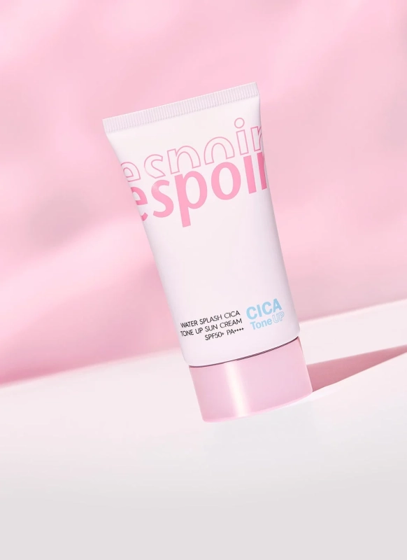 ピンクの背景に置かれた、白とピンクのチューブ型の日焼け止めクリーム「espoir WATER SPLASH CICA TONE UP SUN CREAM SPF50+ PA++++」