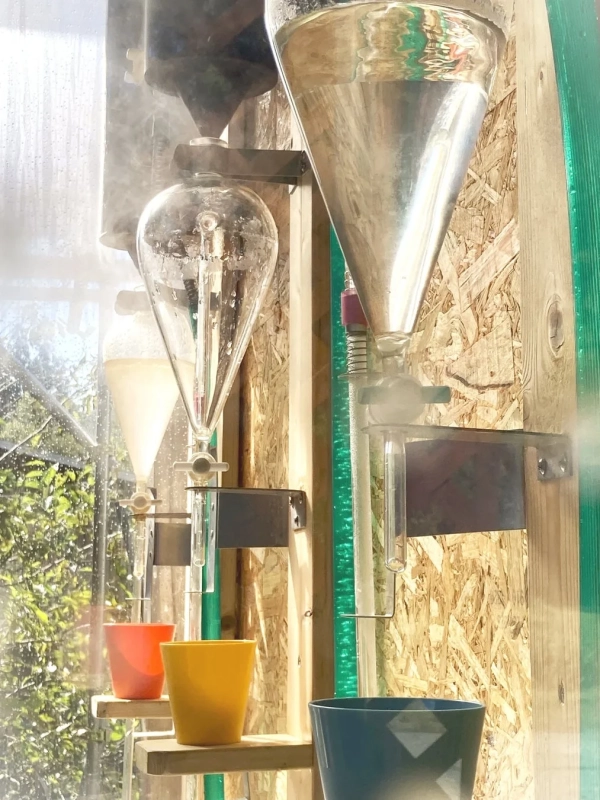 科学実験のようなガラス器具で液体を抽出している様子