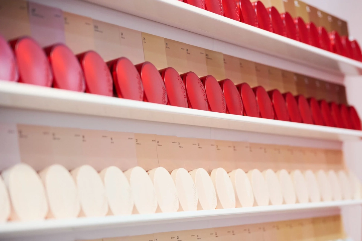 白い棚にESPOIRブランドの化粧品コンパクトが多数並べられたディスプレイ