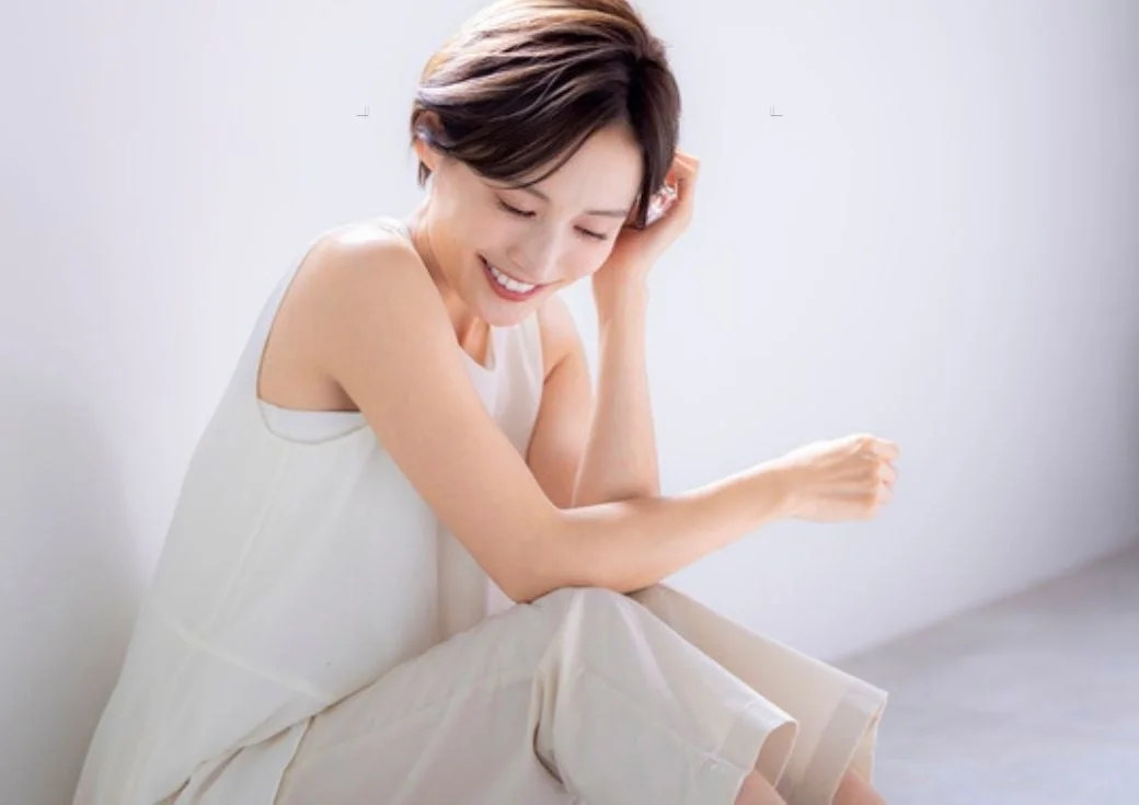 白い服を着たショートヘアの女性が笑顔