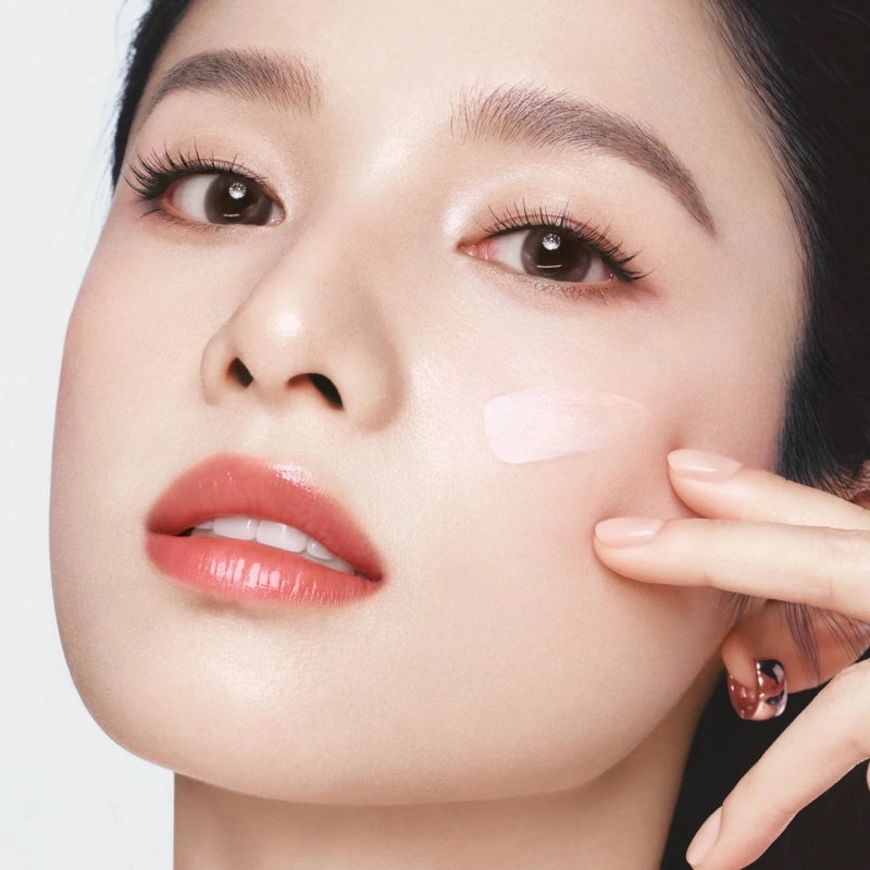 女性の頬にクリームを塗布する様子