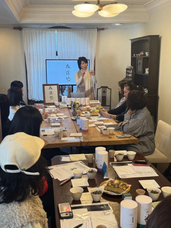 「森羅塾」の看板がある室内で、女性が講師としてお茶のワークショップを開催している画像
