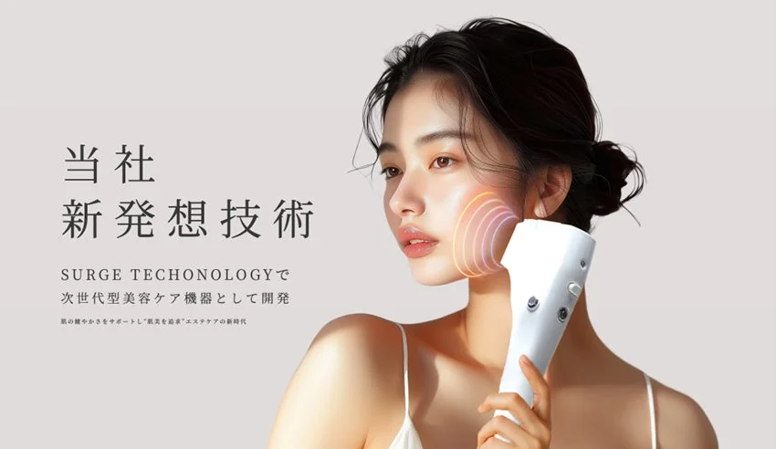 顔に美容機器を当てている女性が映っており、新発想技術「SURGE TECHONOLOGY」による次世代型美容ケア機器のプロモーション画像です。肌の健やかさと美しさを追求するエステケアの新時代を提案しています。