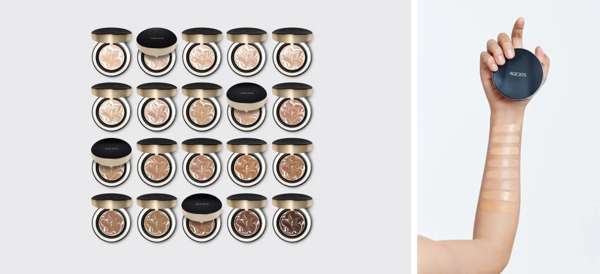複数のクッションファンデーションが様々な色合いで並べられており、そのうちの一つを手に持った腕に、異なるシェードのファンデーションを塗布したスウォッチが示されています