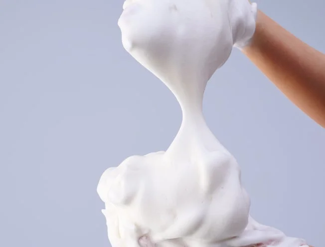 手が白い濃厚な泡を伸ばしている様子