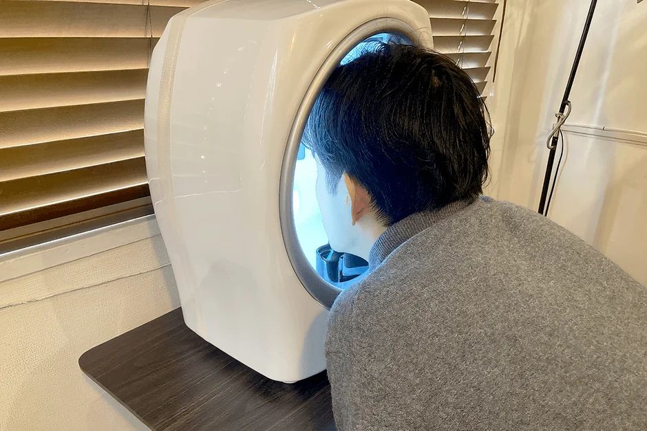 男性が肌診断機器に顔を入れている様子