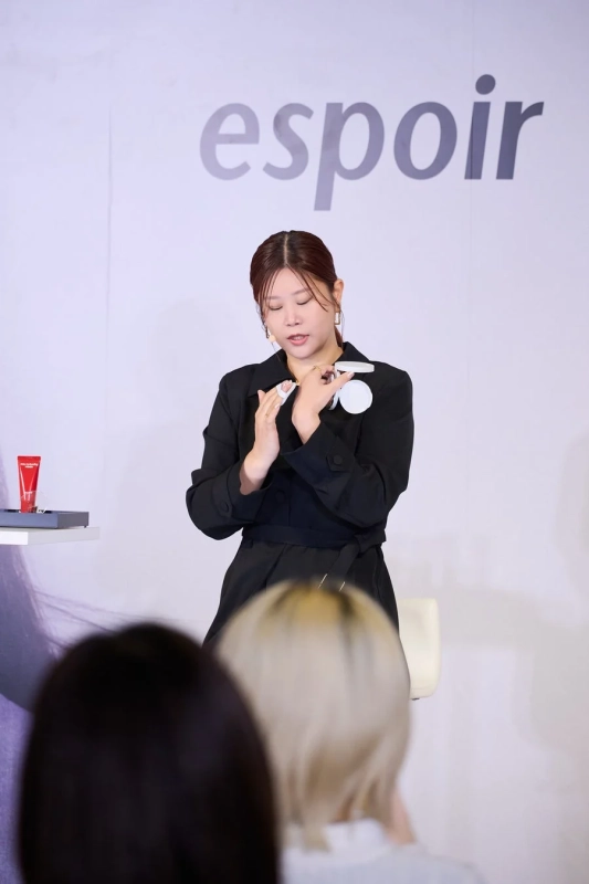 美容イベントで、女性がespoirのクッションファンデーションとパフを使って実演