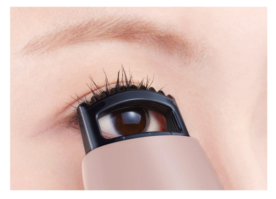 ビューラーでまつ毛をカールさせている女性の目元