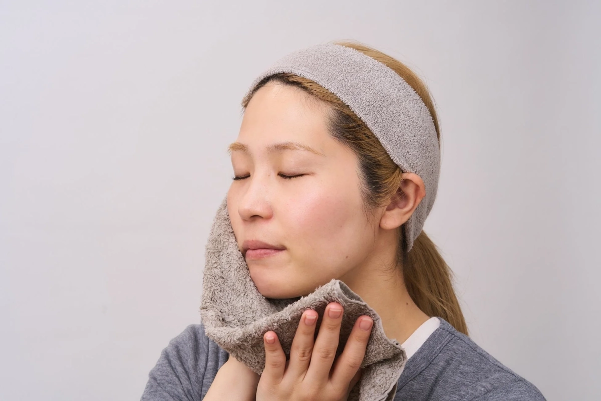 タオルで顔を拭いている画像