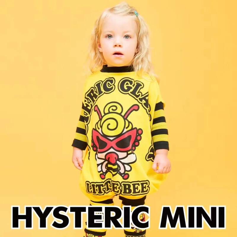 金髪の幼児が、黄色い蜂のキャラクターと「LITTLE BEE」の文字がプリントされた黄色い服を着て立っています。