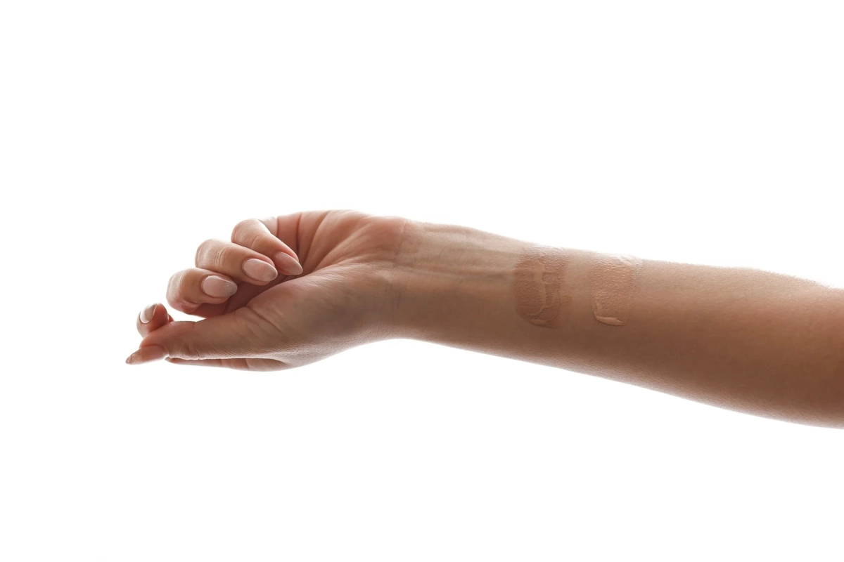 女性の手首に複数のファンデーションが塗られ、色味を比較している様子