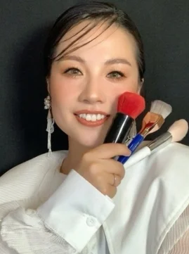 メイクブラシを持つ笑顔の福岡美波さん