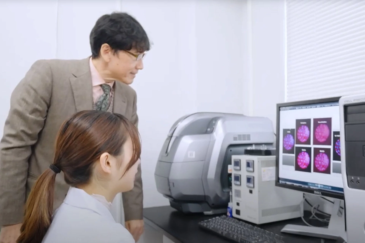 研究室でPCモニターを見ながら議論する研究者