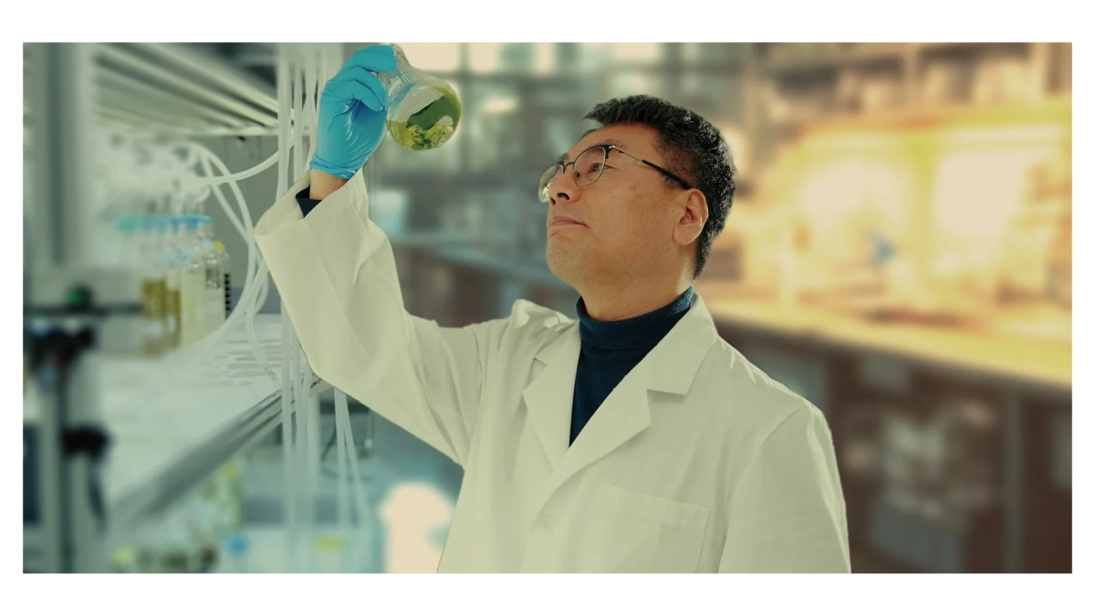 科学者がフラスコを観察する様子