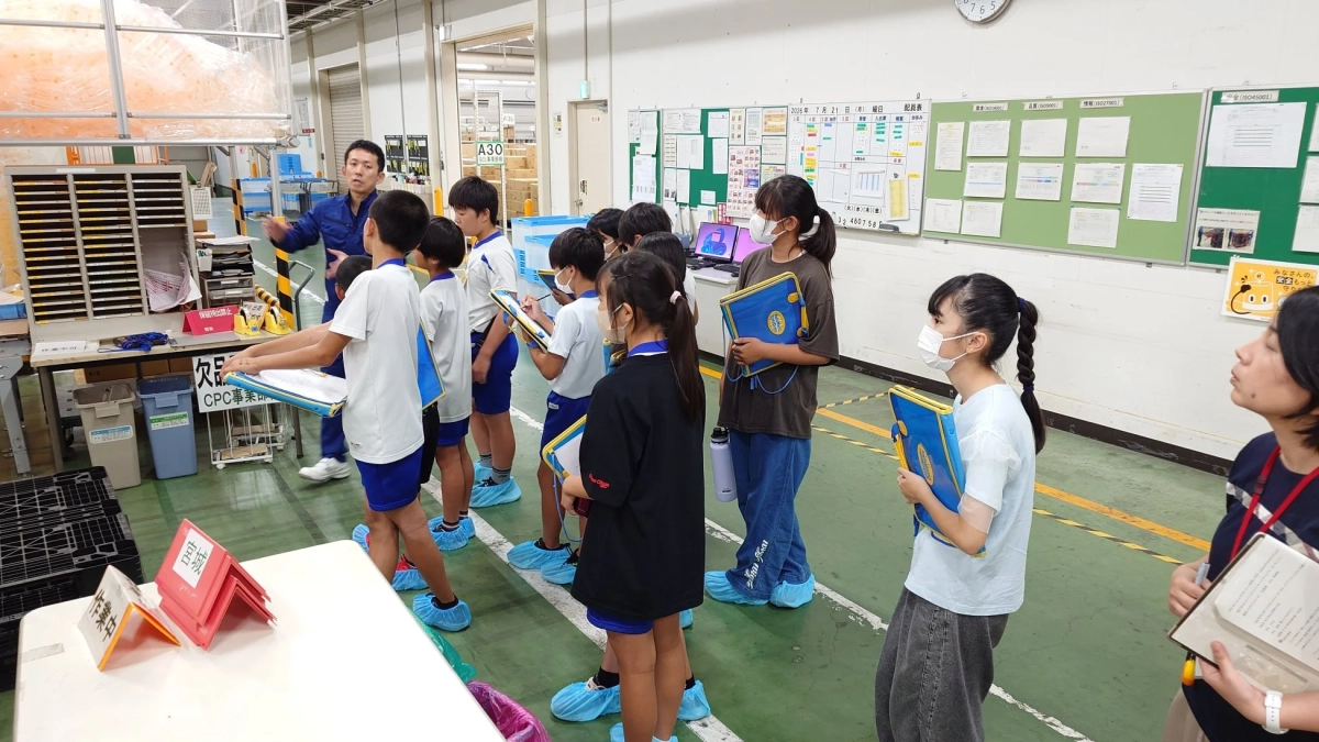 工場見学中の子供たち、説明を受ける