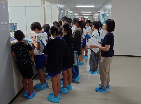 工場見学中の子供たち、品質管理エリア